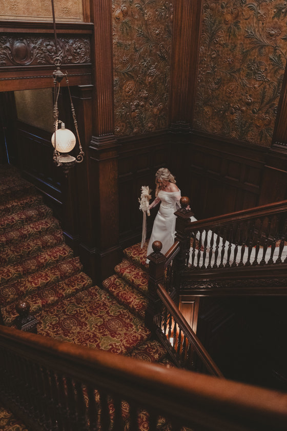 Bride walking down Norwood Hall Hotel's grand staircase